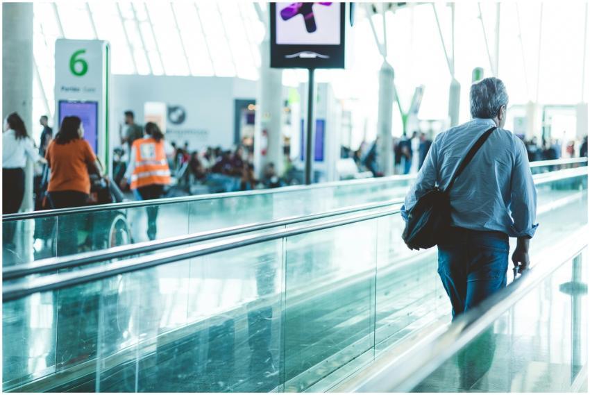 A bustling airport scene with travelers on a movin
