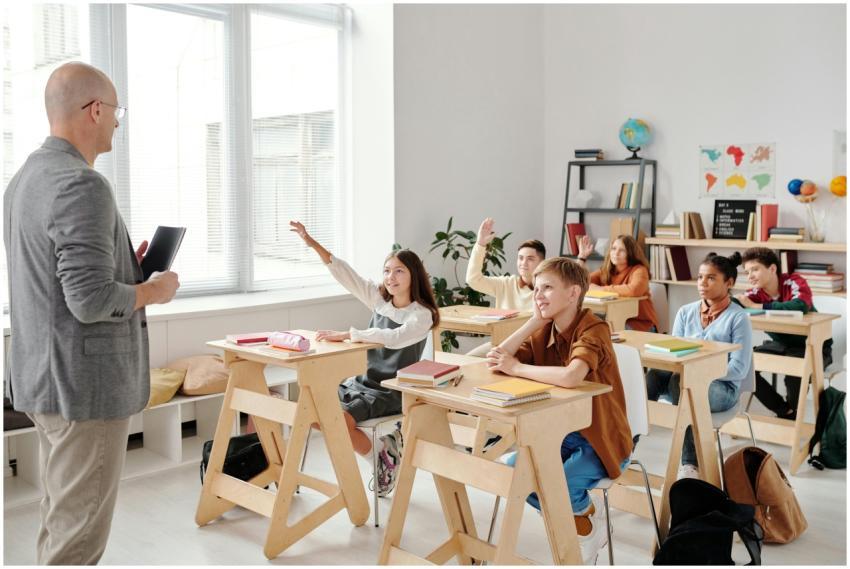 Students engage eagerly in a classroom, raising ha