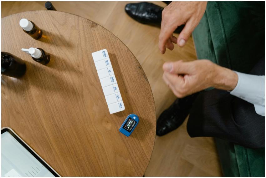 Senior man sorting medication on a wooden table, h