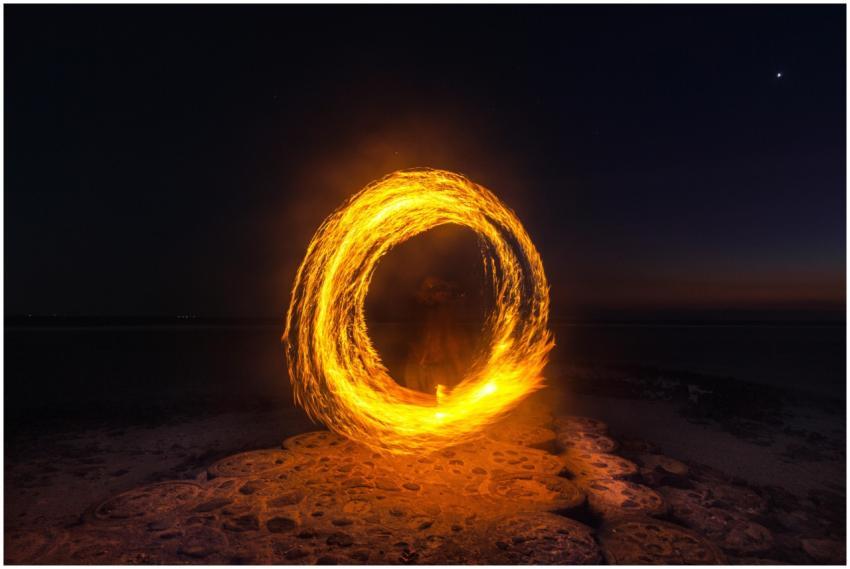 Captivating long exposure shot of a fire dancer cr
