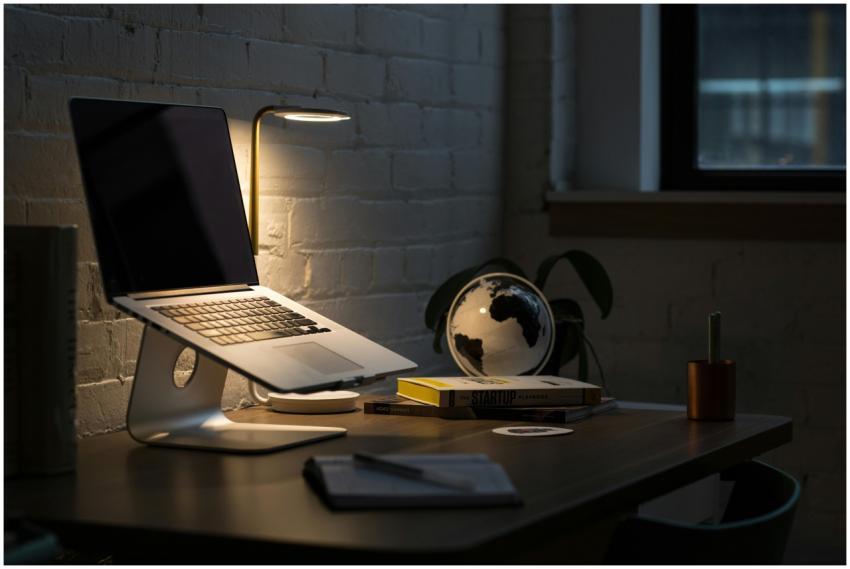 A modern workspace featuring a laptop, books, and