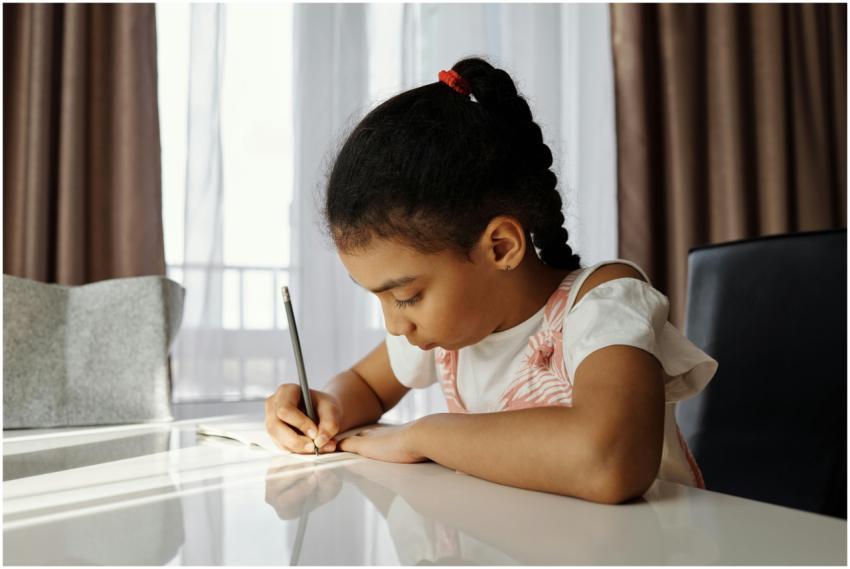 A focused young girl writing at her desk, absorbed