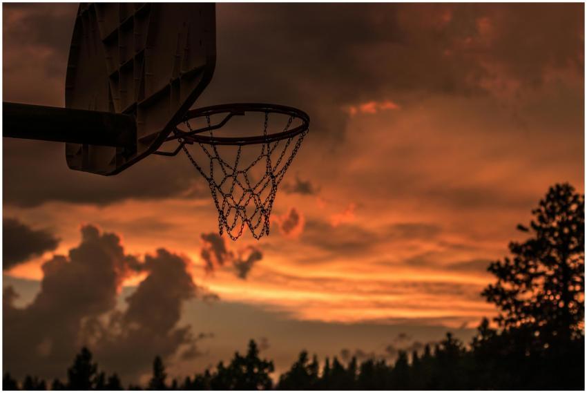 Silhouette of a basketball hoop with vibrant sunse