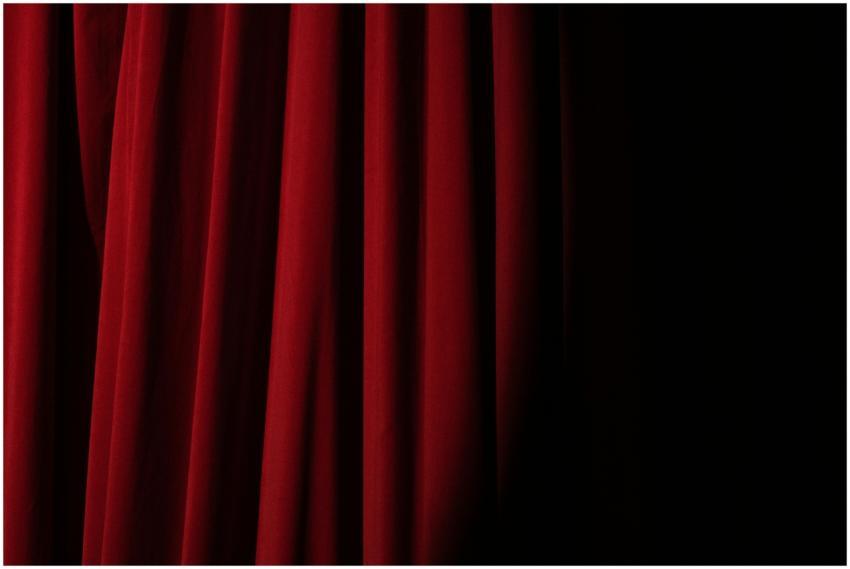 Elegant red velvet curtain with dramatic lighting