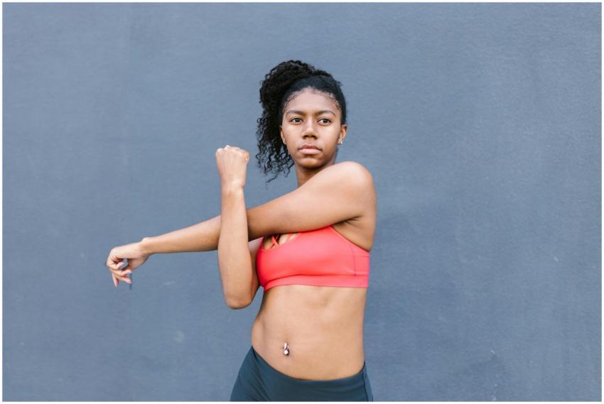 African American woman in activewear stretching ou