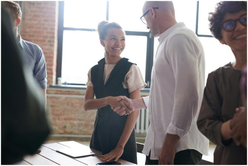 A diverse group exchanging a handshake in a bright