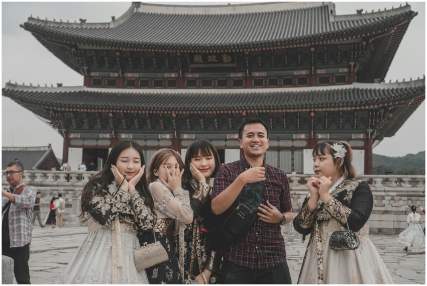 Tourists posing in front of Gyeongbokgung Palace,