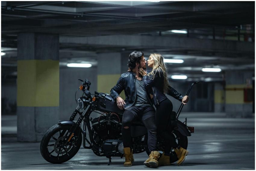 A couple embraces on a motorcycle in an undergroun