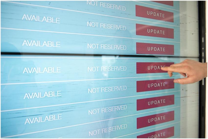 A hand interacts with a digital touchscreen interf