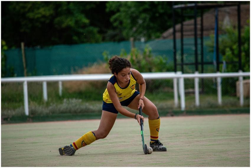 Young female field hockey player intently focused