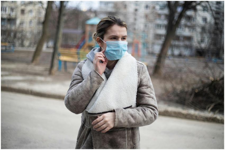 A woman outdoors wearing a face mask for protectio