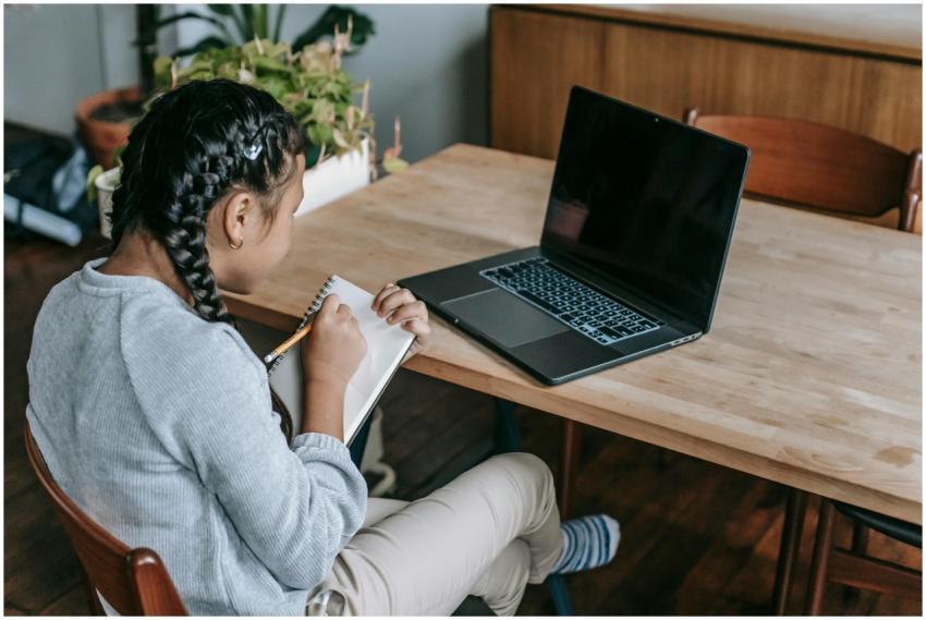 Young girl concentrating on schoolwork using a lap