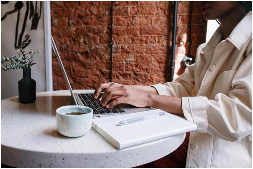 Woman working on a laptop with coffee in a cozy ca