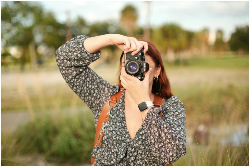 Woman using camera outdoors capturing nature, show