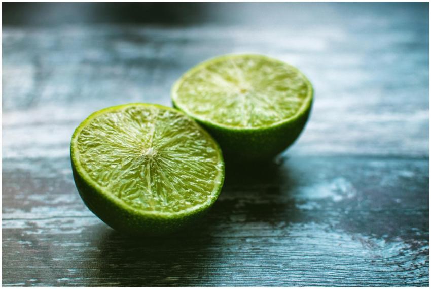 Vibrant green lime halves on a rustic wooden surfa