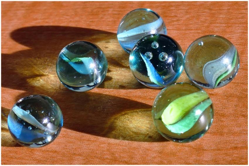 A vivid collection of glass marbles casting colorf