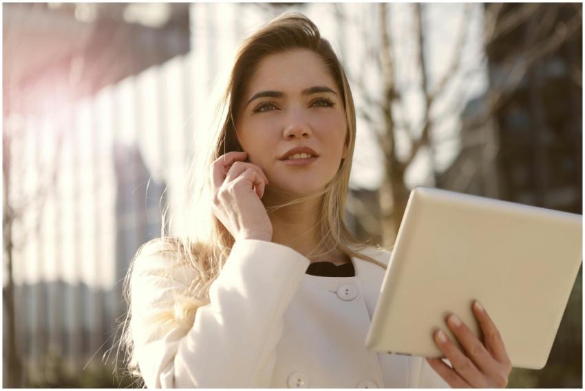 Confident woman holding a tablet, communicating on