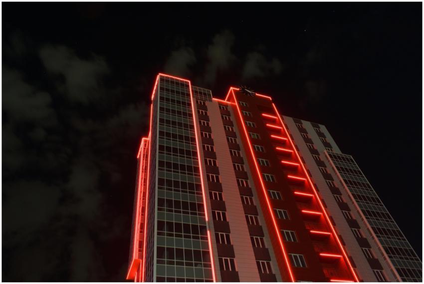 A striking view of a skyscraper with red neon ligh