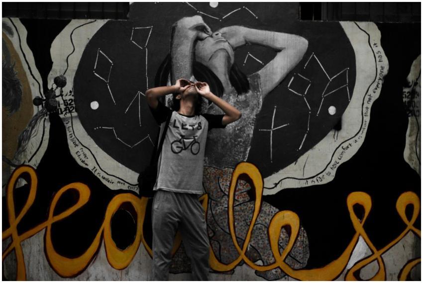 An urban scene featuring a person posing in front