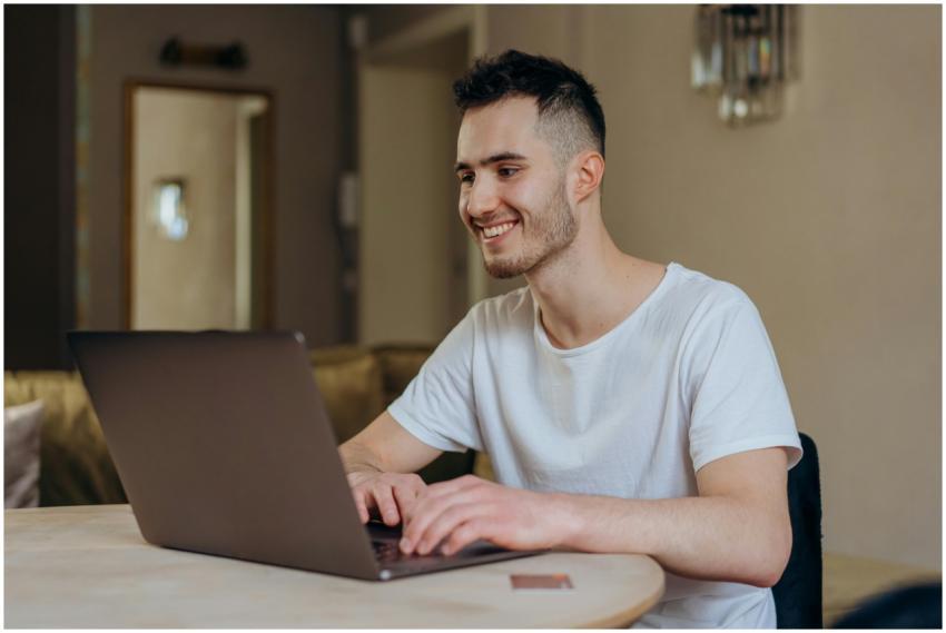 Young man smiling while online shopping with lapto