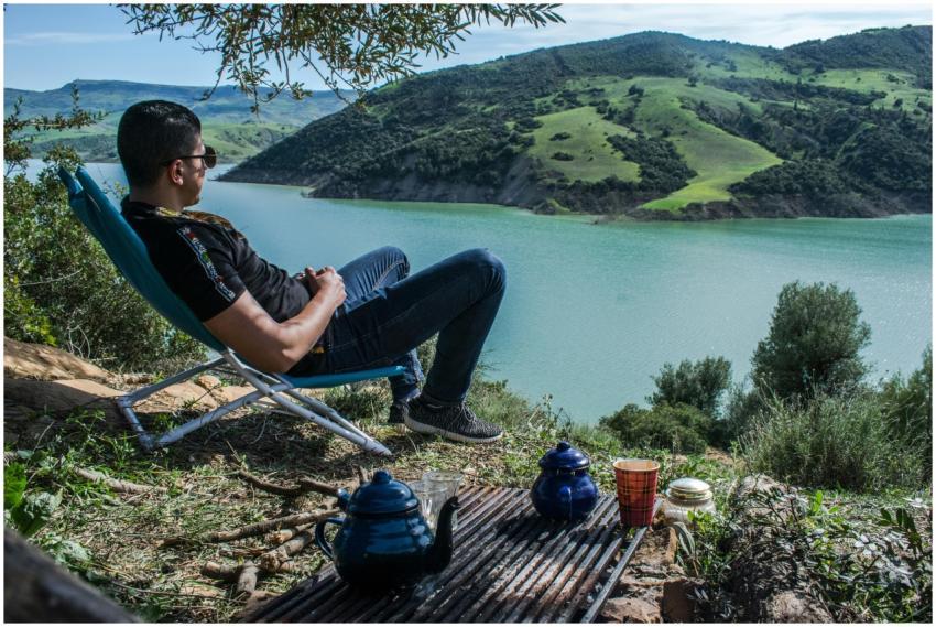 A man relaxing by a scenic lake in Blida, Algeria,