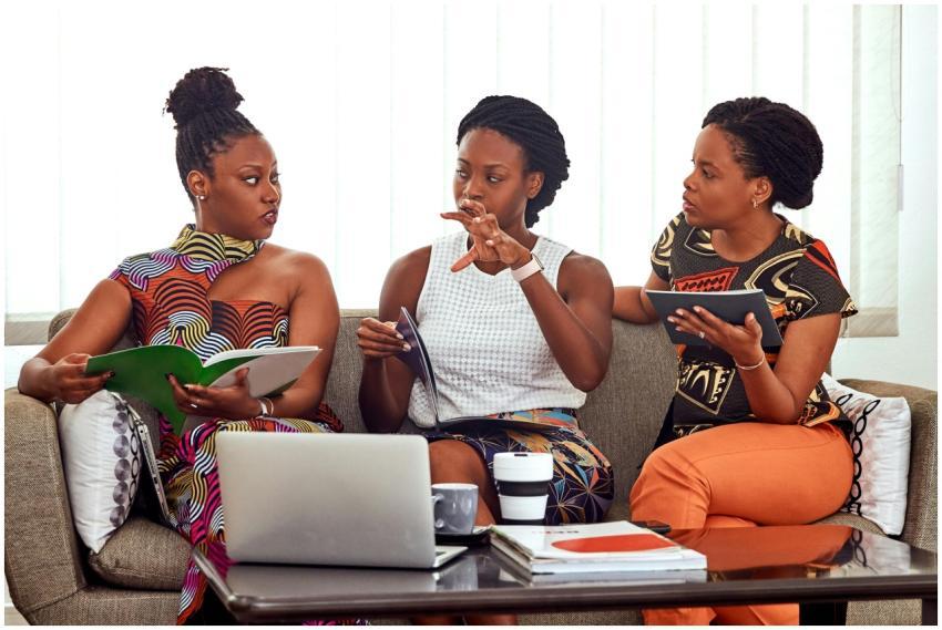 Three African American women engaged in a collabor