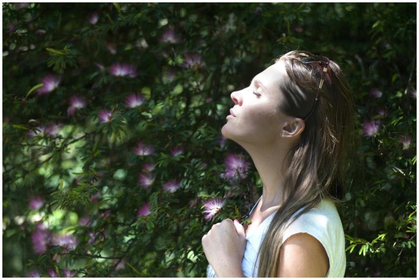 A woman enjoying a serene moment in a sunlit garde