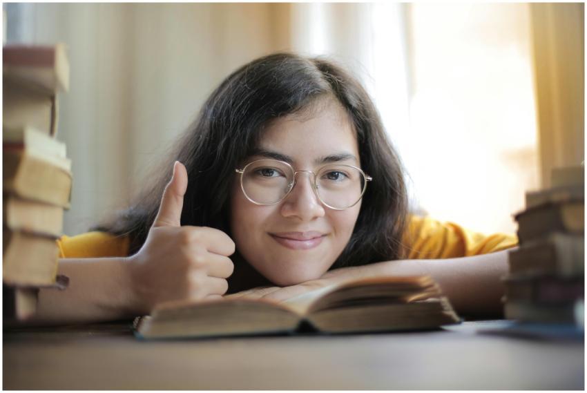 Portrait of a happy woman with glasses giving a th