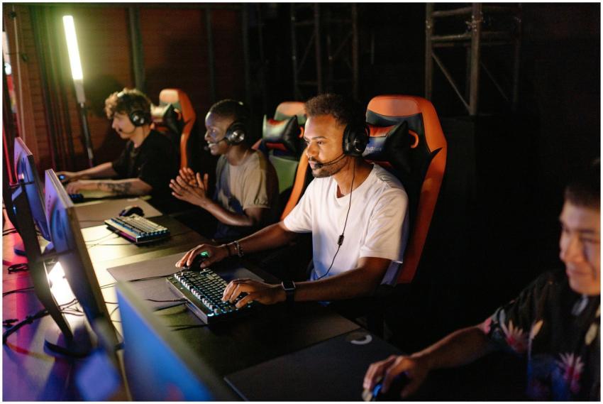 A group of young adults intensely focused on a com