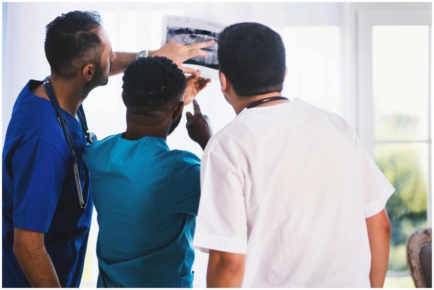 Doctors collaboratively analyzing an X-ray in a cl