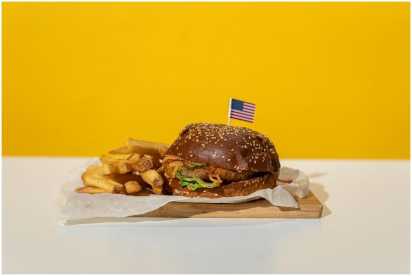 Delicious hamburger with fries served on wood agai