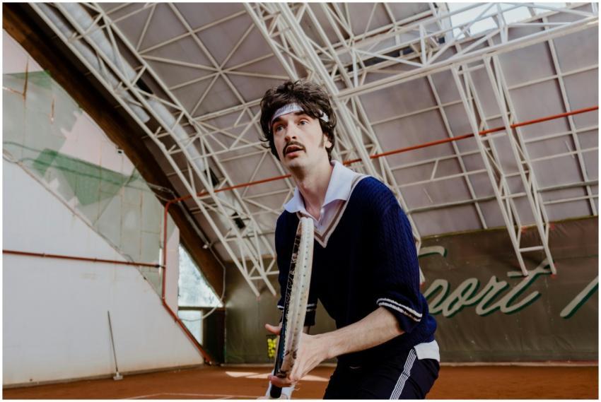 Focused tennis player poised on an indoor court, r