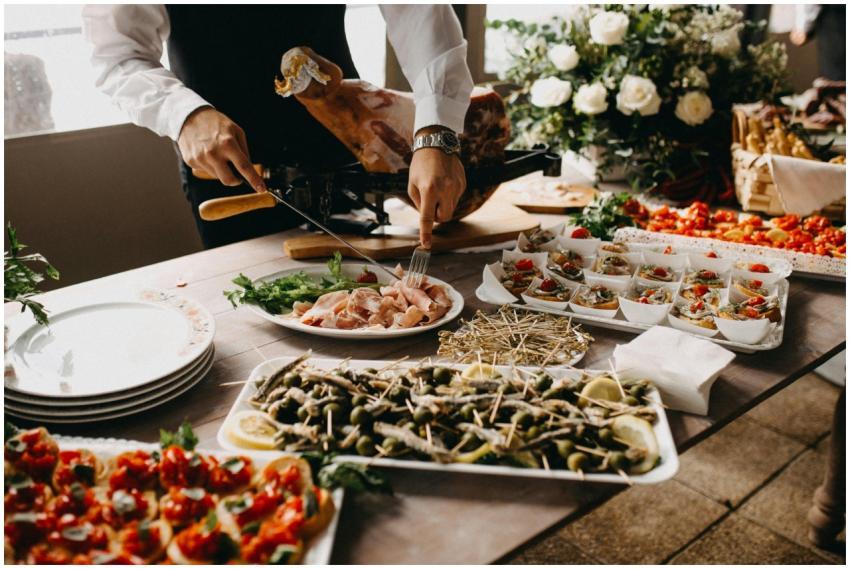 A chef slices meat in a beautifully arranged cater
