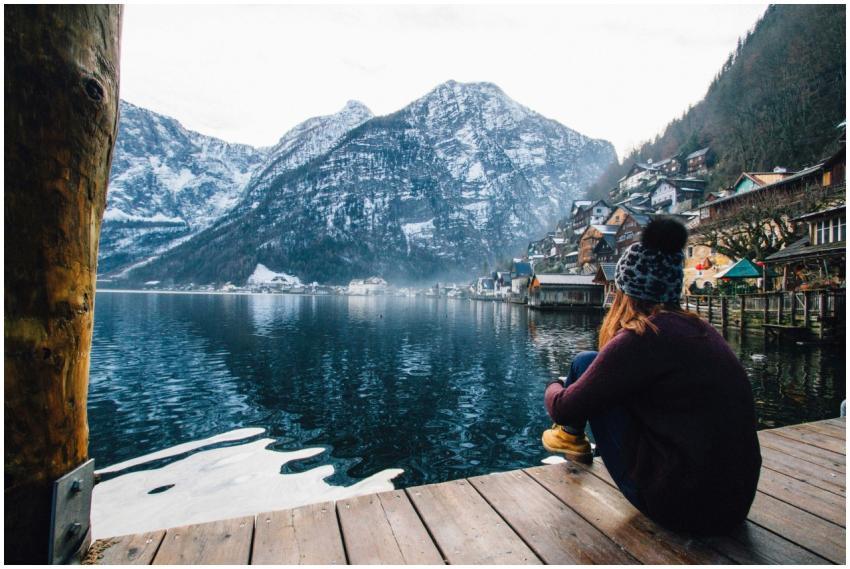 A woman sits on a dock overlooking the serene Hall
