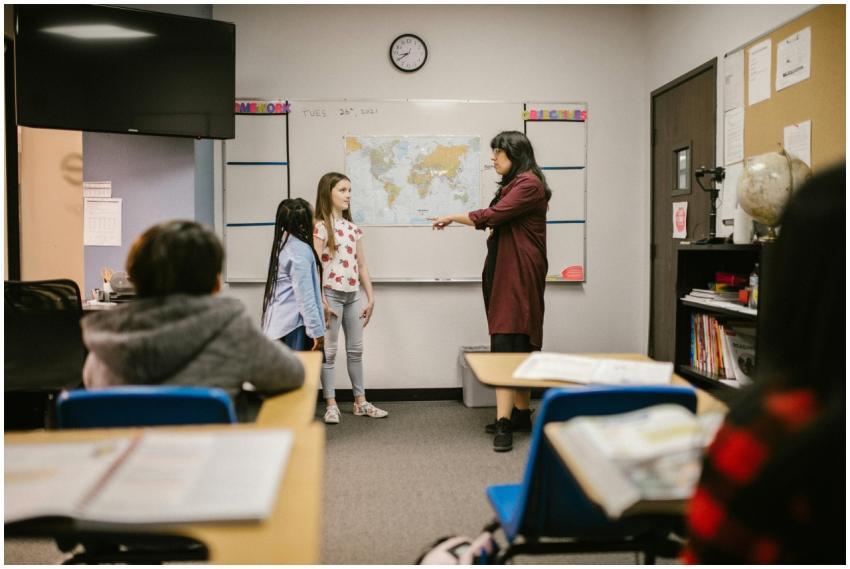 A teacher instructs students in a classroom with a