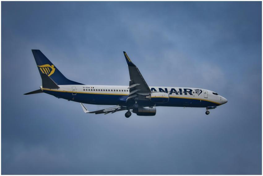 A Ryanair airplane in flight against a cloudy sky,