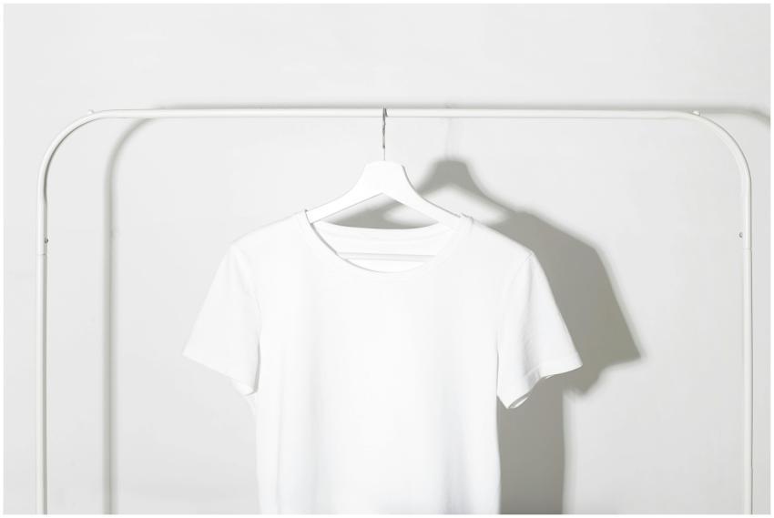 Plain white t-shirt on a hanger against a minimali