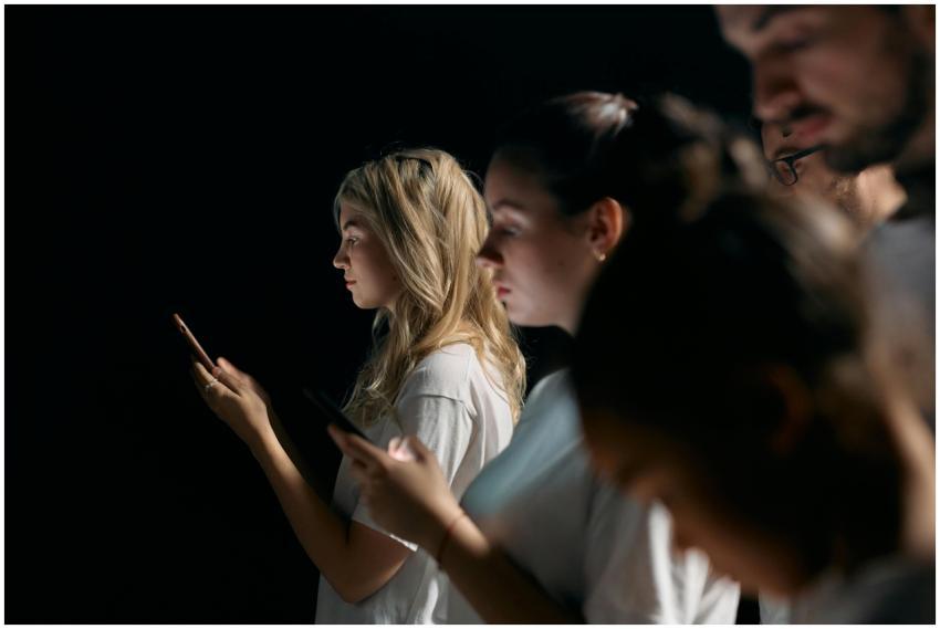 A group of young adults focused on their smartphon