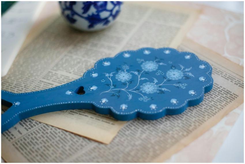 Intricate blue hand mirror with floral design plac