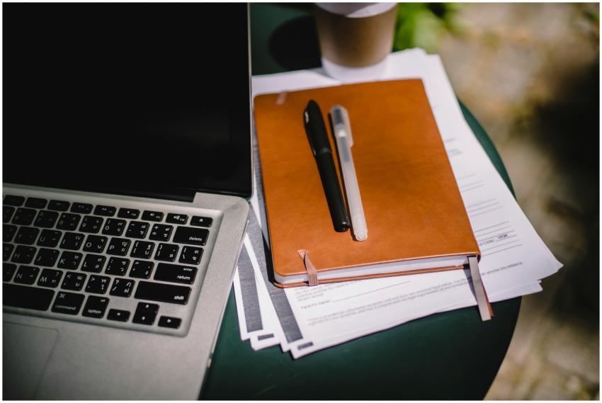 Overhead view of a workspace with a laptop, notebo