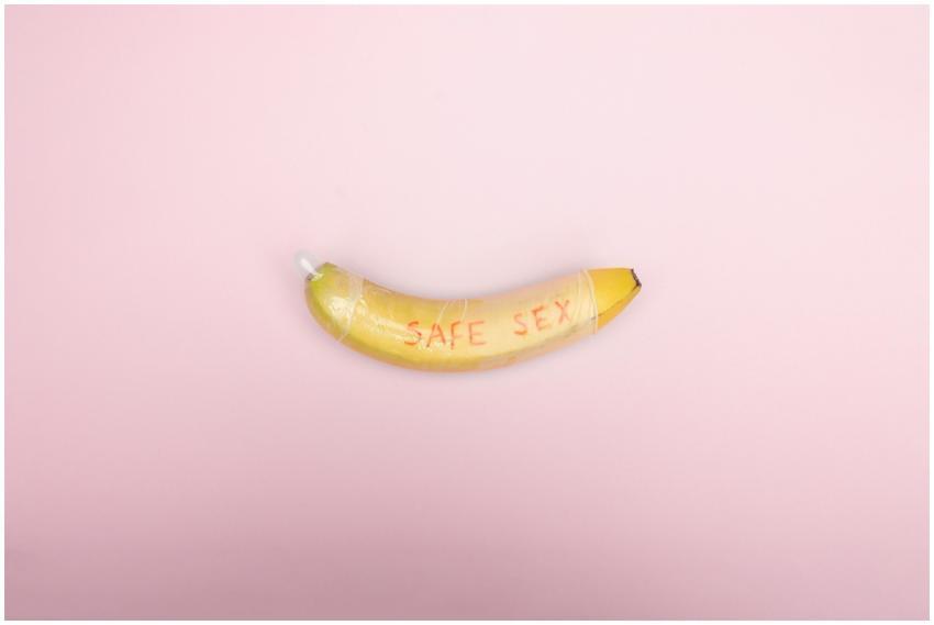 Still life image of a banana wrapped in a condom w