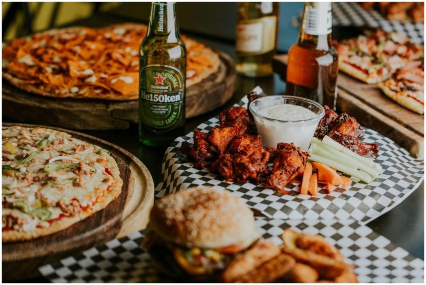 Mouth-watering pizza, beer, and chicken wings plat
