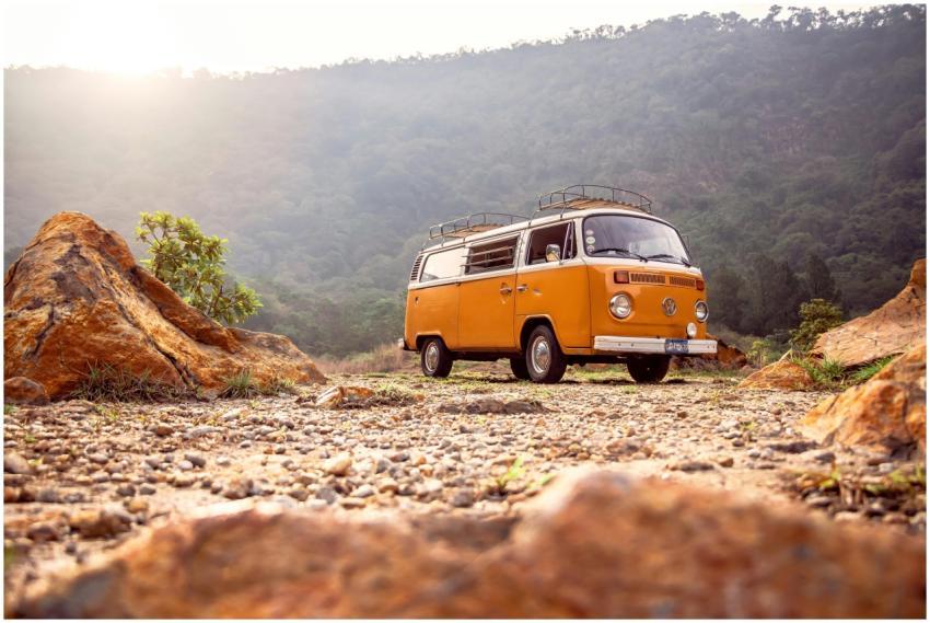 Classic VW van parked on rocky terrain with mounta