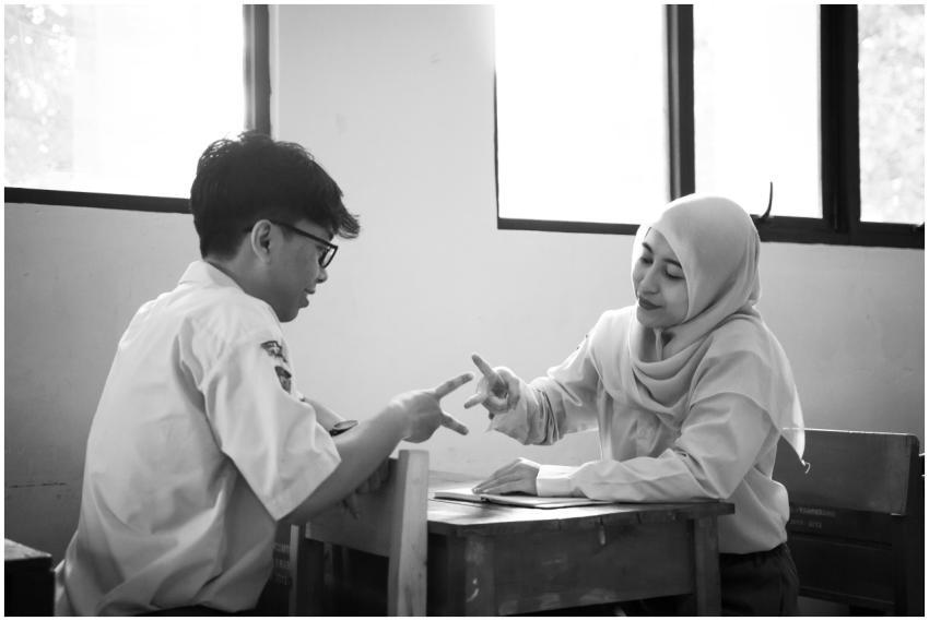 Two students playing rock paper scissors in school
