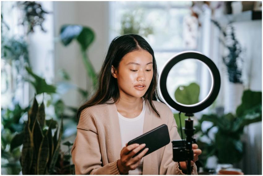 Asian woman adjusting smartphone and ring light in