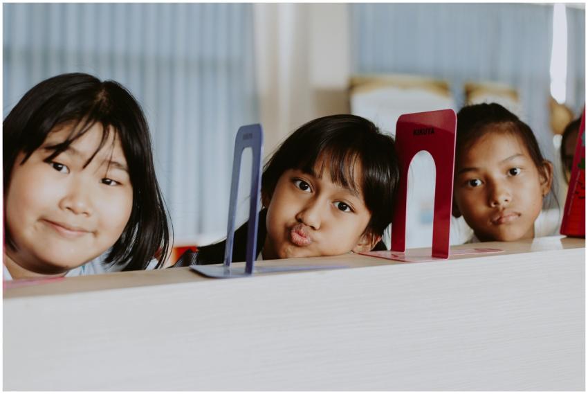 Three children engaging in playful expressions dur
