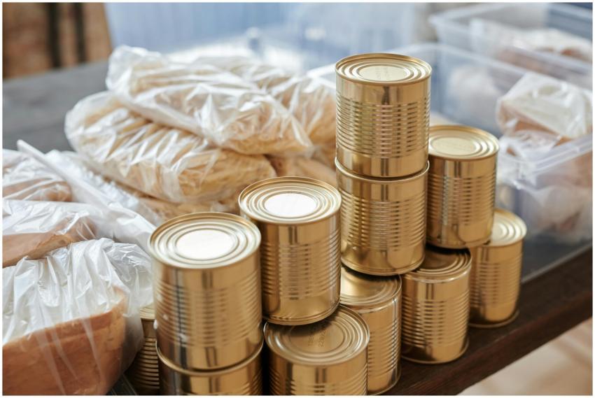 A stack of canned goods and packaged foods on a ta