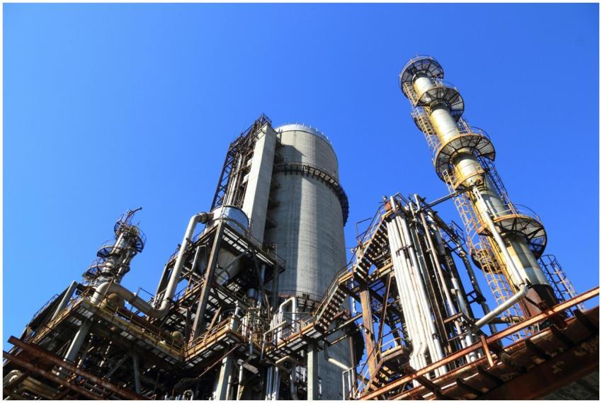 A towering industrial plant under a vivid blue sky