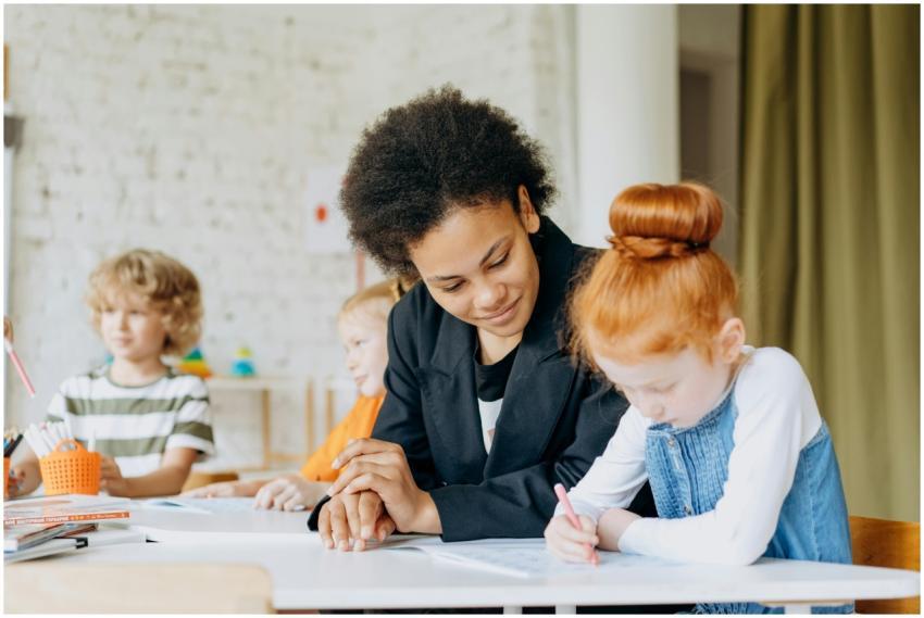 A teacher helps children with writing in a classro