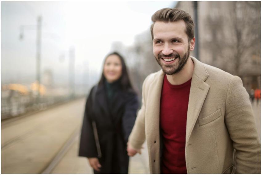 Happy young couple holding hands and smiling on a